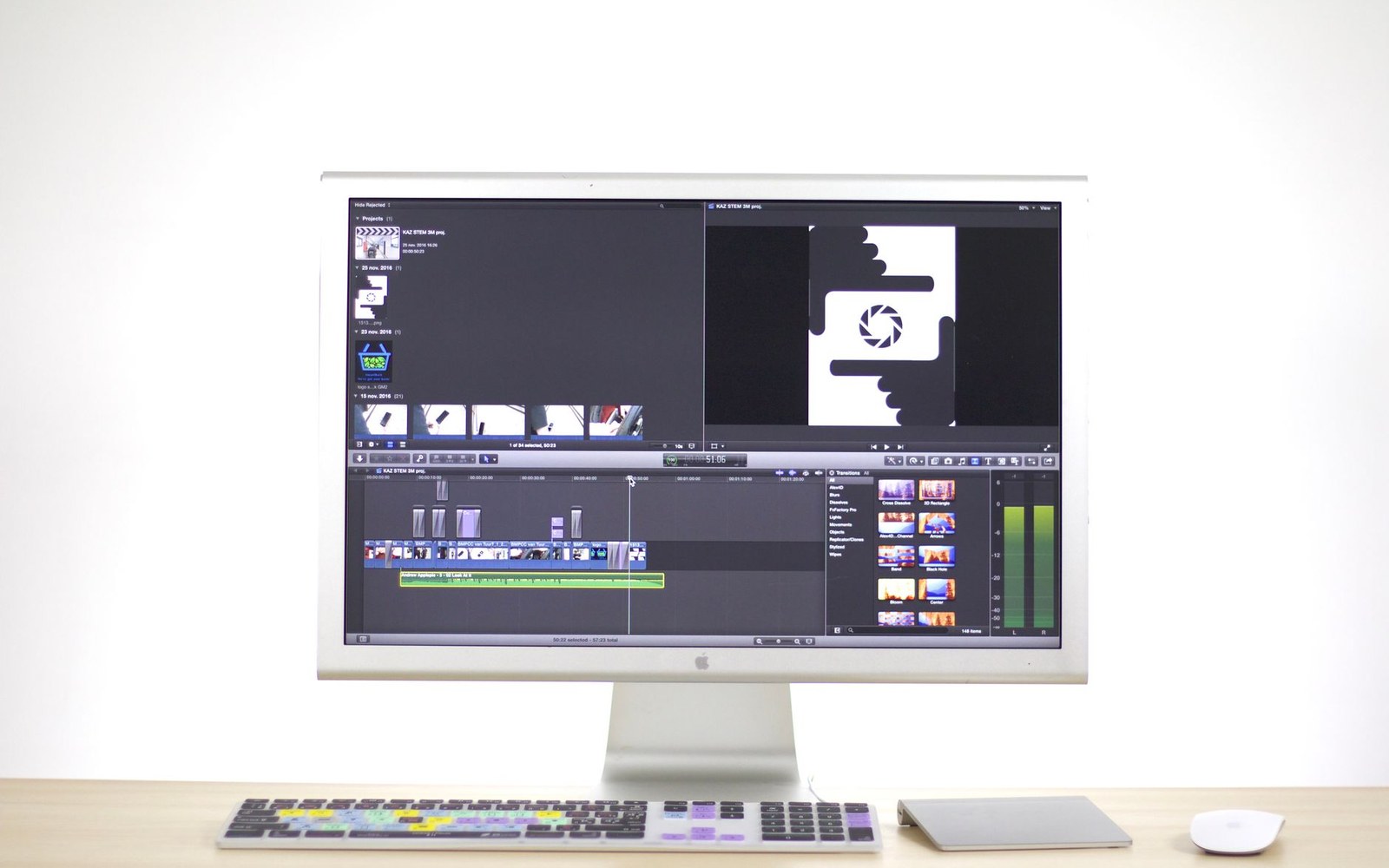 An iMac displaying video editing software with a timeline and preview window on screen